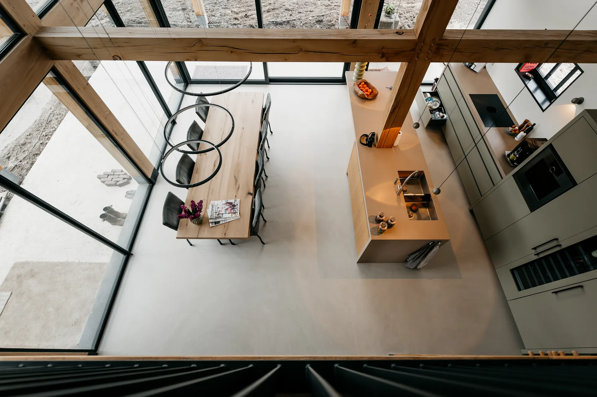 PU betonlook gietvloer in open woonkamer met vide