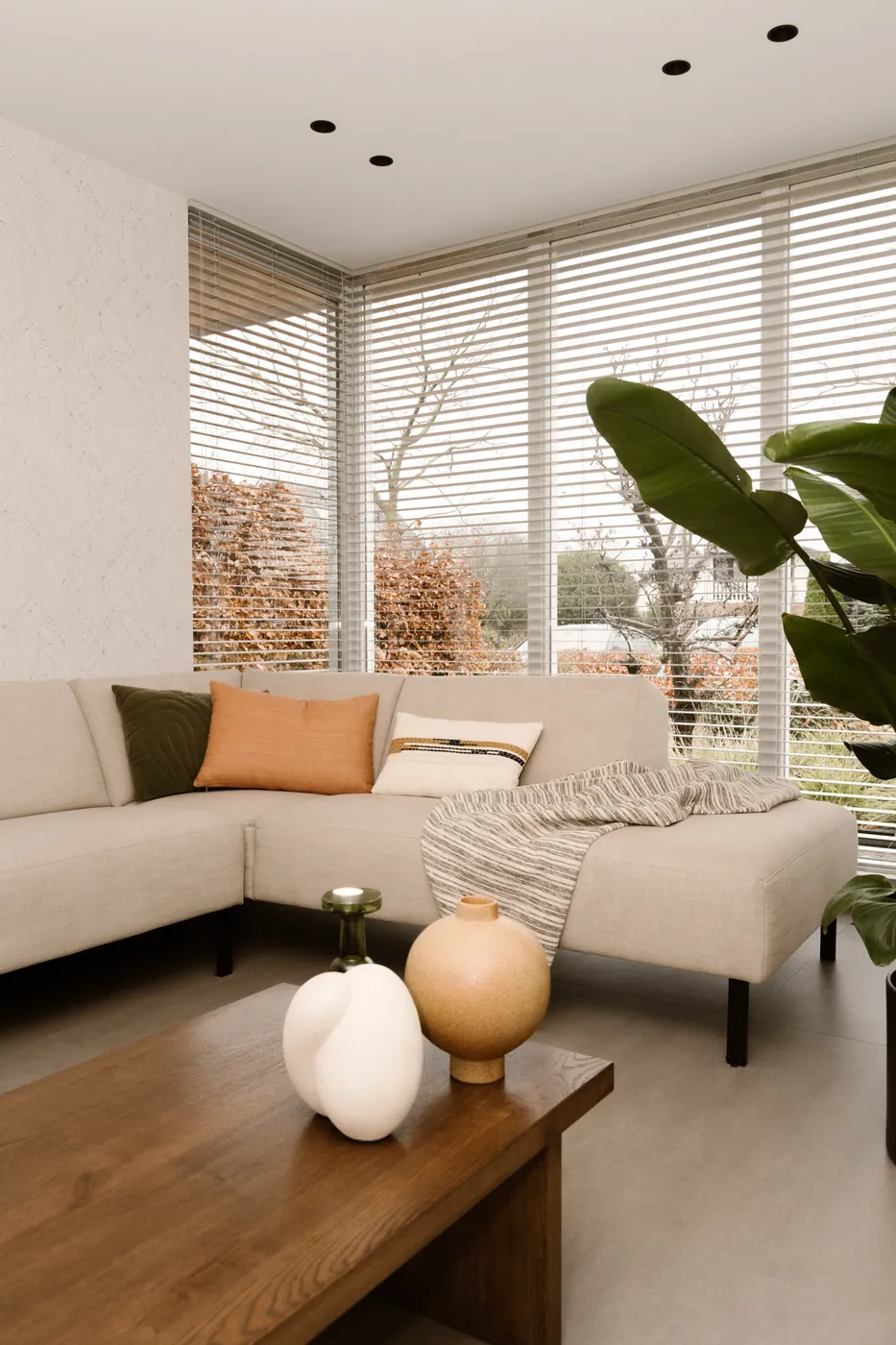 Lichtgrijze pvc-vloer in tegellook bij een loungehoek