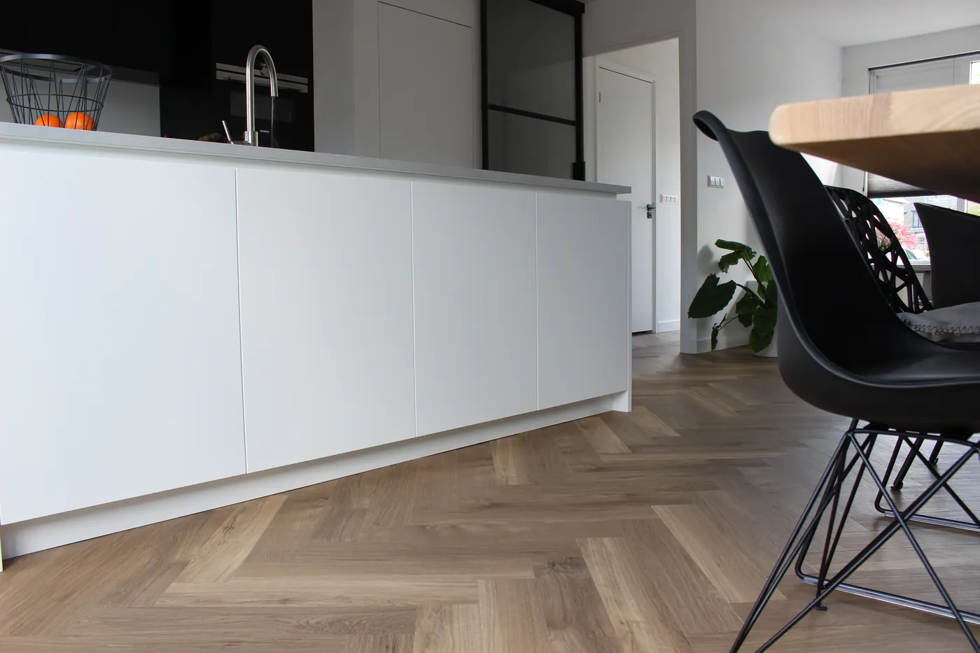 Wit keukeneiland op zandbruine visgraat pvc vloer