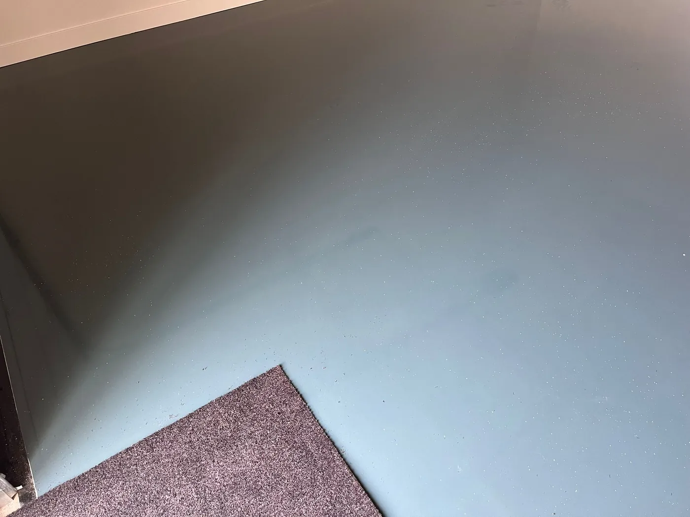 Grijsblauwe epoxyvloer met fijne lichte spikkels