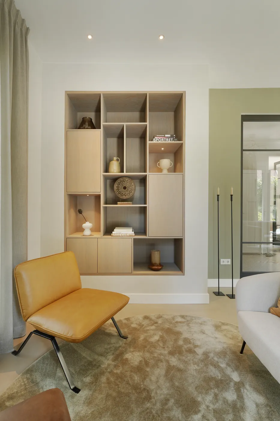 Taupe gietvloer bij een okergele lounge fauteuil