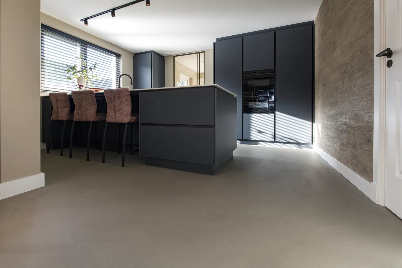 Taupe gietvloer in een keuken met kookeiland