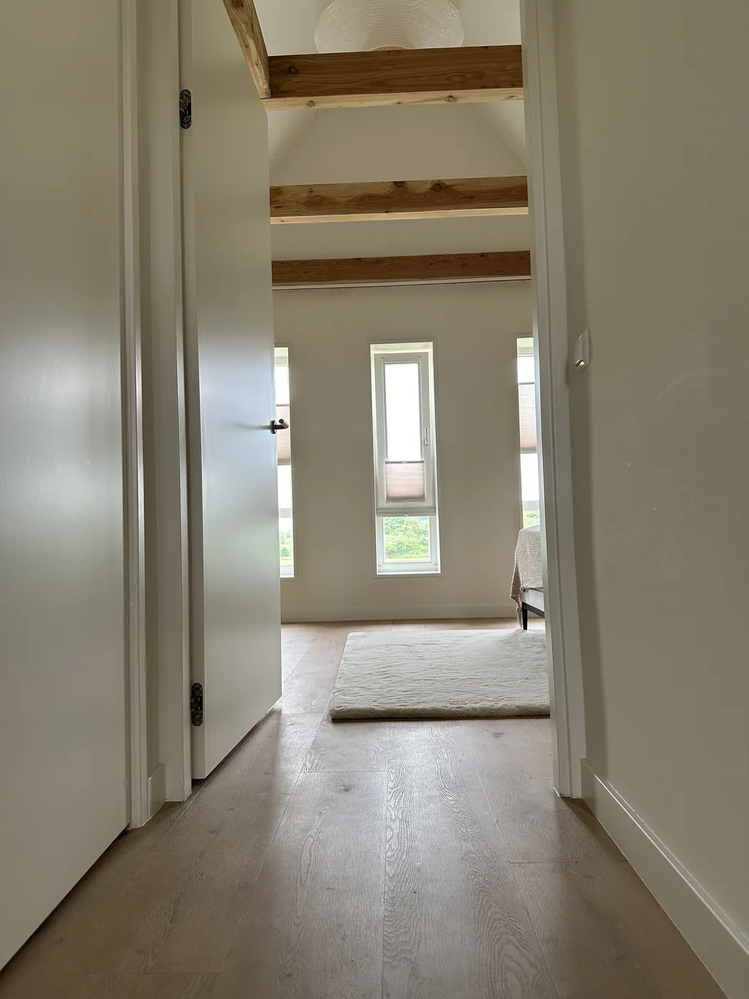 Pvc plankvloer op de overloop met witte leuning
