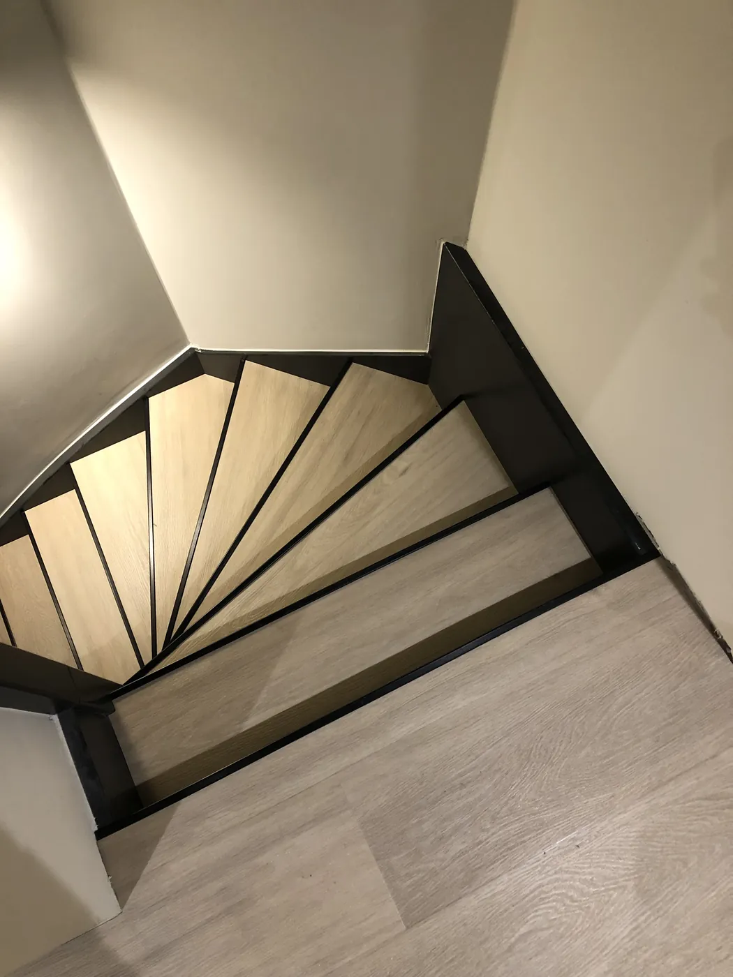 Trap met licht eiken pvc-treden sluit aan op de vloer