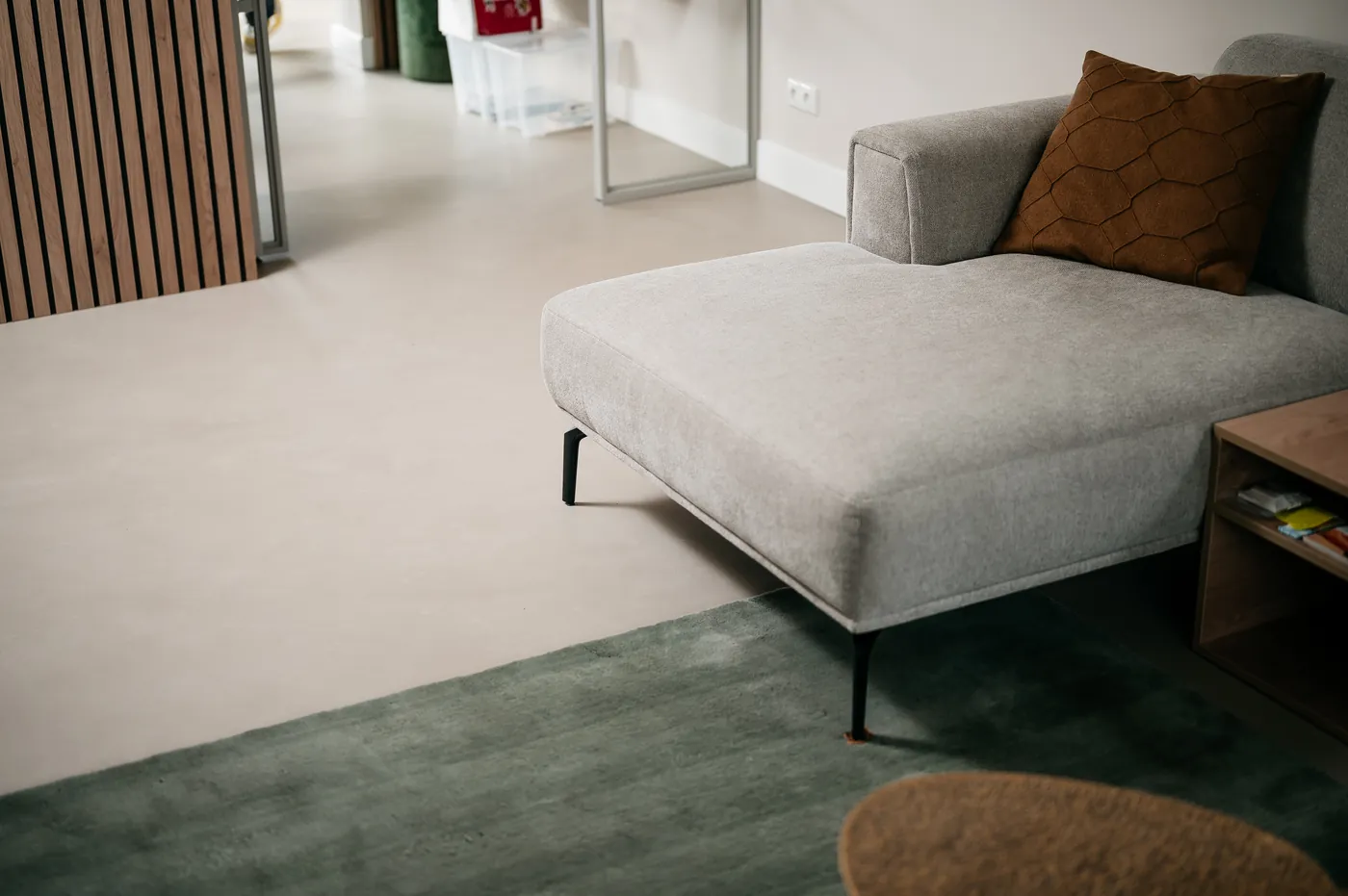 Taupe gietvloer gecombineerd met een bruine bank