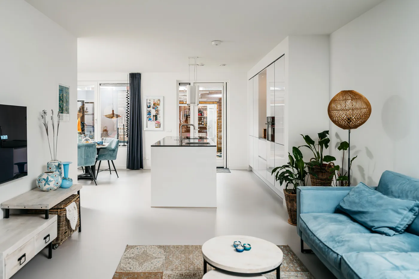 Witte uni gietvloer in een open woon- en eetkamer