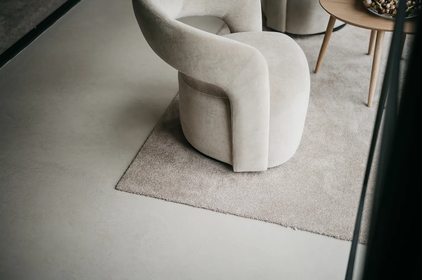 Crème fauteuil op een klein vloerkleed