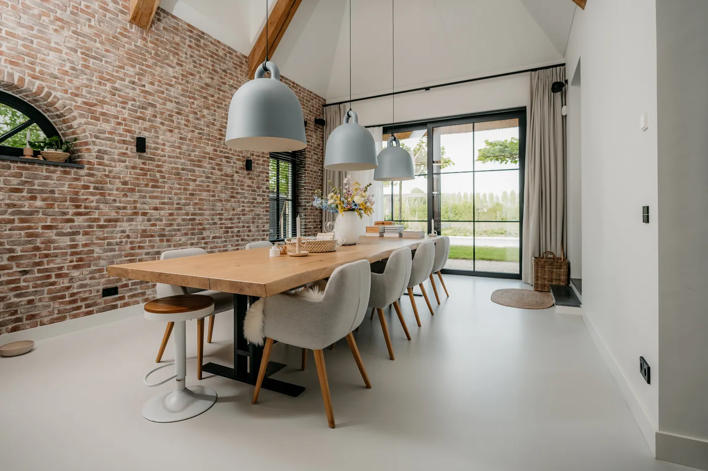 Eetkamer met lange eiken tafel op witte gietvloer